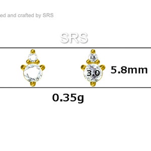 May include: Gold-tone earring with three clear cubic zirconia stones. The earring is 5.8 mm in diameter and weighs 0.35 grams.  SRS.