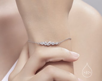 May include: A silver bracelet with a row of small, clear, teardrop-shaped stones.