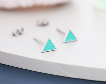 May include: A pair of silver triangle stud earrings with turquoise enamel. The earrings are small and delicate.