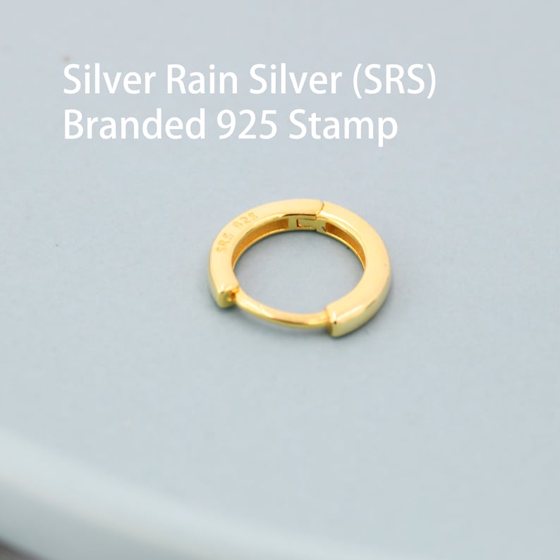 May include: A gold hoop earring with a 925 stamp. The earring is made of silver and is a simple, classic design.