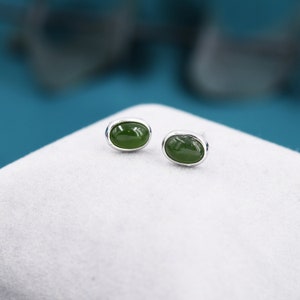 Puede incluir: Un par de pendientes de plata con piedras de jade verde de forma ovalada.