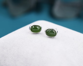 Puede incluir: Un par de pendientes de plata con piedras de jade verde de forma ovalada.