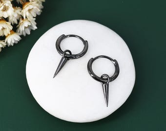 May include: A pair of black hoop earrings with a sharp, pointed spike hanging from each hoop.