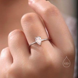 以下が含まれることがあります： 洋梨型の透明な宝石がついた銀の指輪