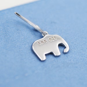 May include: A silver elephant charm with the inscription "SRS 925" on the back.