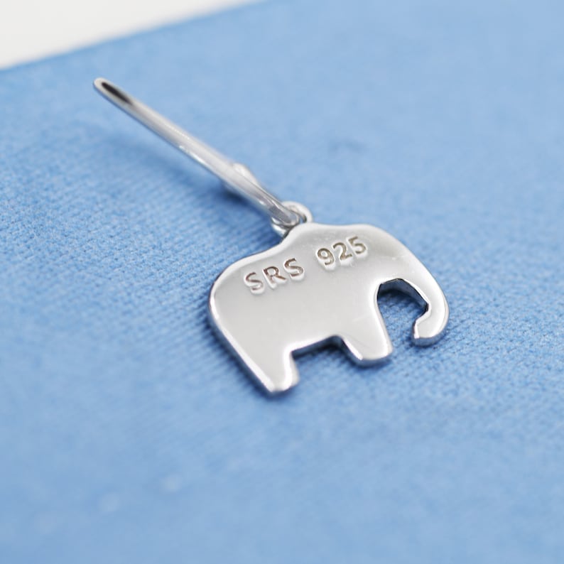 May include: A silver elephant charm with the inscription "SRS 925" on the back.
