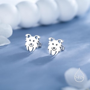 May include: A pair of silver stud earrings featuring a dog silhouette design. The earrings are small and delicate, perfect for everyday wear.