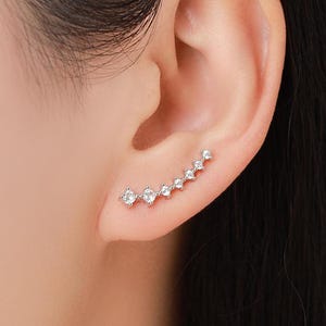Pendientes de plata de ley con forma de oreja y brillantes cristales de circonita cúbica, en plata, oro u oro rosa.