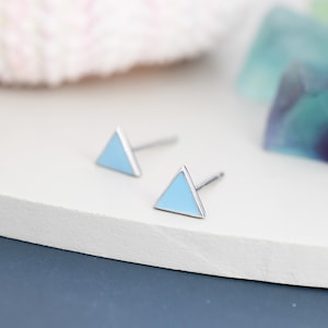 Könnte beinhalten: Ein Paar silberne Dreiecks-Ohrstecker mit hellblauer Emaille-Füllung.