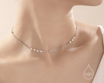 May include: A delicate silver necklace with a dainty chain and small heart charms. The necklace is a simple and elegant piece of jewelry.