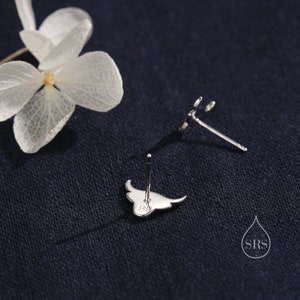 May include: A pair of silver stud earrings featuring a manta ray design. The earrings are marked with "S925" on the back.