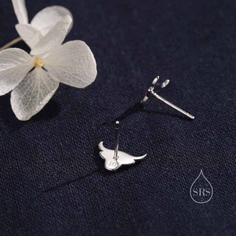 May include: A pair of silver stud earrings featuring a manta ray design. The earrings are marked with "S925" on the back.