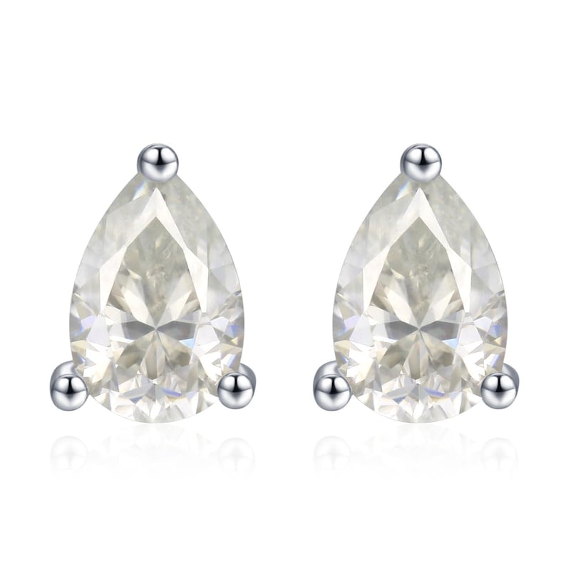 May include: A pair of pear-shaped stud earrings. Each earring features a clear, faceted gemstone set in a silver-colored metal. The earrings have a simple, elegant design, with a small silver ball at the top and two at the bottom.