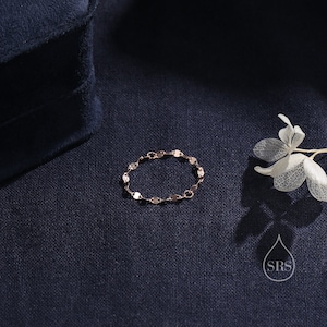 May include: A delicate gold chain bracelet with a linked design. The bracelet is on a dark blue fabric background.