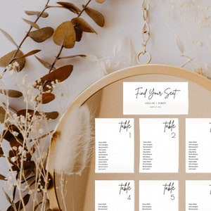 May include: A white mirror with a gold frame displays a seating chart for a wedding reception. The chart is titled "Find Your Seat" with the couple's names and wedding date. The chart is divided into six sections, each labelled with a table number from 1 to 6.