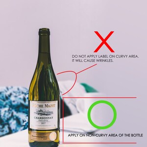 K&ouml;nnte beinhalten: Eine gr&uuml;ne Glasflasche Wein mit einem wei&szlig;en Etikett, auf dem "Roche Mazet Chardonnay Pays d'Oc 2017" steht. Das Etikett enth&auml;lt auch den Text "Cover Speciale Rondeux & Equilibre". Eine Illustration zeigt, wie man ein Etikett auf die Flasche aufbringt, wobei darauf hingewiesen wird, dass das Etikett auf einen nicht gekr&uuml;mmten Bereich der Flasche aufgebracht werden sollte, um Falten zu vermeiden.