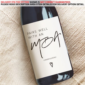 May include: A white wine bottle label with black text that reads "Pairs well with an MBA. Congratulations!" with a small heart symbol.