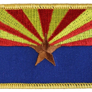 May include: An embroidered patch featuring the Arizona state flag. The flag is blue with a red and yellow sunburst design and a copper-colored five-pointed star in the center.