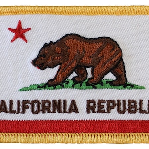 May include: Embroidered patch featuring the California state flag. The patch is white with a red star in the upper left corner, a brown bear walking on green grass, and the words "CALIFORNIA REPUBLIC" in brown text. The patch is bordered by a gold outline and has a red stripe at the bottom.