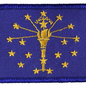 May include: A blue embroidered patch with the state flag of Indiana. The flag features a gold torch with 13 gold stars surrounding it. The word "Indiana" is written in gold above the torch.