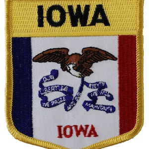 May include: An embroidered patch featuring the state flag of Iowa. The patch is yellow with a blue, white, and red shield in the center. The shield features an eagle, a blue ribbon with the words "Our Liberties We Prize And Our Rights We Will Maintain", and the word "Iowa" in red letters.