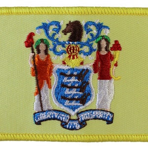 May include: A yellow embroidered patch with the state seal of New Jersey. The seal features a horse, two women, and a shield with three blue and white stripes. The text "LIBERTY AND PROSPERITY" is written on a blue ribbon.