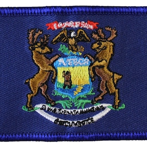 May include: A blue embroidered patch with the state seal of Michigan. The seal features a shield with a bald eagle, a sunrise, and a bear. Two elk flank the shield, and the words "Tuebor" and "Si Quaeris Peninsulam Amoenam Circumspice" are inscribed on a ribbon.