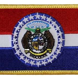 May include: A blue, white, and red embroidered patch with the state seal of Missouri. The seal features two bears, a shield, and the words "United We Stand, Divided We Fall".