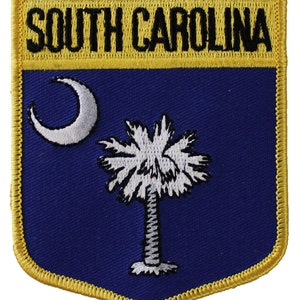May include: A blue and yellow embroidered patch with the words "SOUTH CAROLINA" and the state flag featuring a crescent moon and palmetto tree.
