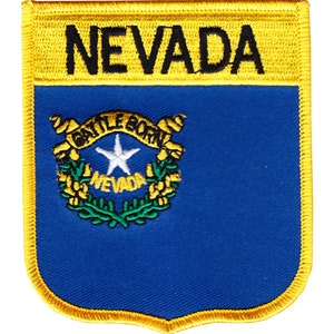 May include: A blue and yellow embroidered patch with the state seal of Nevada and the word "NEVADA" in black lettering.