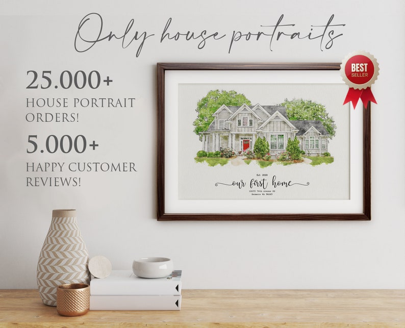 Op de afbeelding: Een aquarel van een huis met een rode deur, omringd door groene bomen en struiken. Het schilderij is ingelijst in een bruin frame en heeft de tekst "ons eerste huis" onder het huis. Het schilderij hangt aan een witte muur met een vaas en andere decoratieve items op een houten tafel ervoor.