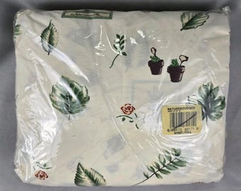 May include: A full-size sheet set in a cream-colored fabric featuring a botanical print of green leaves, small red flowers, and brown potted plants. The package includes a label with the text NATUREWOOD GRN and a barcode.