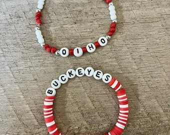 May include: Two beaded bracelets with red and white beads. One bracelet spells "O-H-I-O" and the other spells "BUCKEYES".