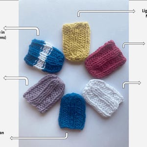 Puede incluir: Una colección de siete pequeños artículos de punto en varios colores, incluyendo rayas azules y blancas, caléndula clara, rosa flor de cerezo, lavanda, blanco brillante y azul cerúleo. Los artículos están dispuestos en un patrón circular.