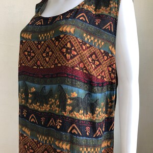May include: A sleeveless dress with a colorful, geometric pattern featuring zebras and floral motifs. The dress is made of a soft, flowing fabric and has a relaxed fit.