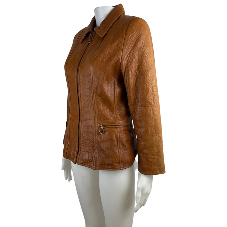 May include: A brown leather jacket with a zip fastening and a collared neckline.