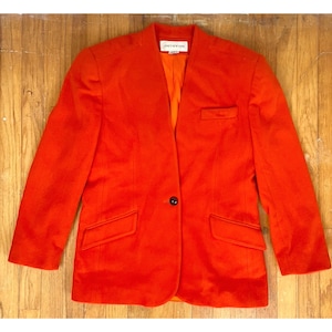 May include: A bright orange blazer with a single button closure and two pockets. The blazer has a label that reads "Jones New York".
