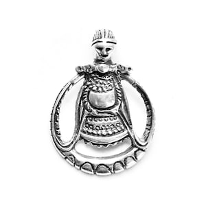May include: Silver pendant featuring a detailed depiction of a woman in a crown and ornate clothing. The pendant is circular and has a raised design.