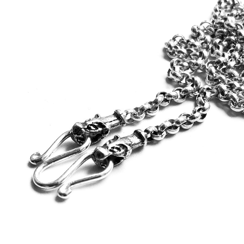 Puede incluir: Un collar de cadena de plata con dos cierres adornados. La cadena es de dise&ntilde;o delicado y trenzado.