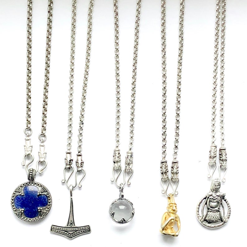 May include: Six silver necklaces with different pendants. The pendants include a blue stone with a four-leaf clover design, a silver hammer, a clear stone, a gold figurine, and a silver figurine.