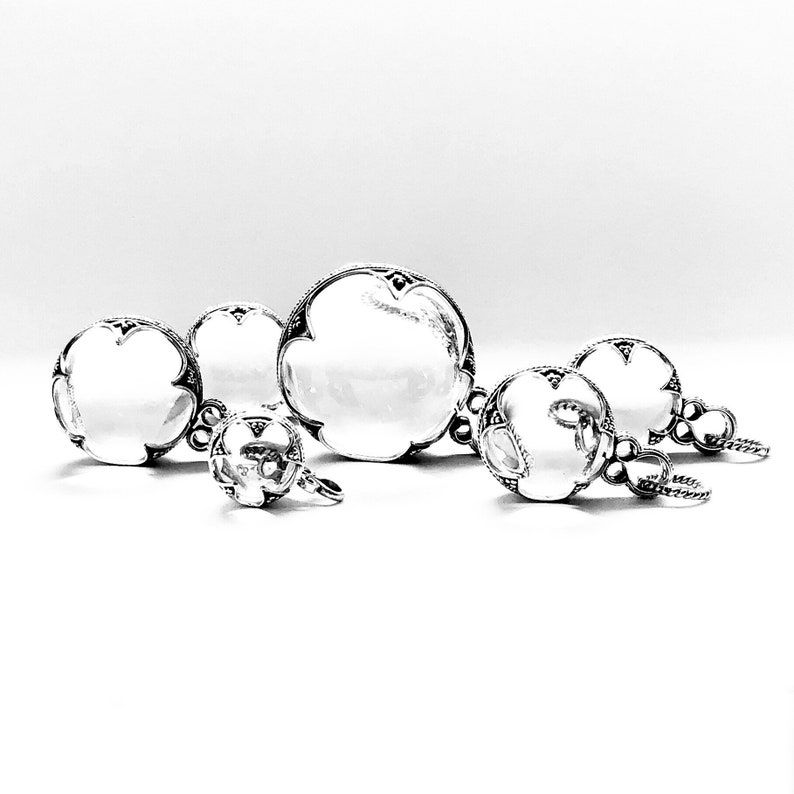 May include: A set of five silver and clear crystal jewellery pieces. The pieces include a pendant, a ring, and a pair of earrings. The jewellery is ornate and features intricate designs.