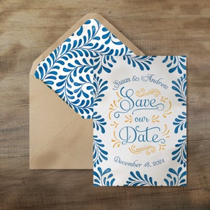 Puede incluir: Tarjeta de guardar la fecha con un patrón floral azul y blanco. La tarjeta dice "Susan & Andrew Save our Date December 18, 2024".