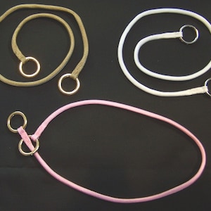 May include: Three different colored cords with metal rings attached. The cords are brown, white, and pink.