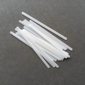 May include: A bundle of white plastic strips, likely for use in crafts or DIY projects.