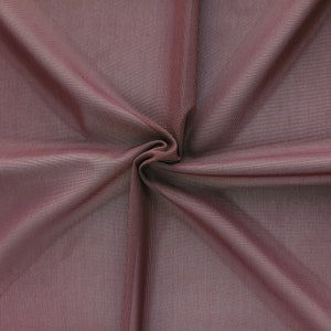 May include: A close-up of a smooth, soft, mauve fabric with a subtle sheen. The fabric is folded and draped, showcasing its texture and drape.