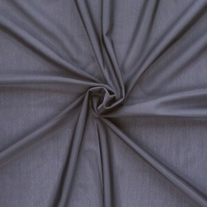 May include: A close-up of a smooth, dark gray fabric with a soft, flowing texture. The fabric is gathered in the center, creating a swirling pattern.