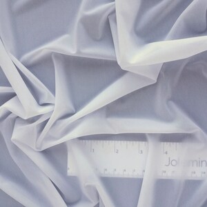 May include: White sheer fabric with a ruler showing 16 inches. The ruler has the word "Jolmina" printed on it.