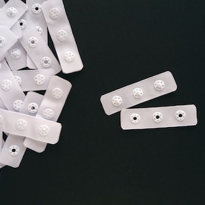 3 round plastic snaps on pre-cut 60 mm (2 3/8") polyester tape with heat sealed edges