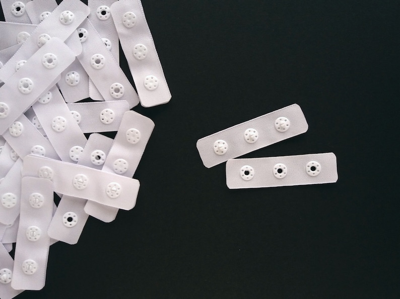 3 round plastic snaps on pre-cut 60 mm (2 3/8") polyester tape with heat sealed edges
