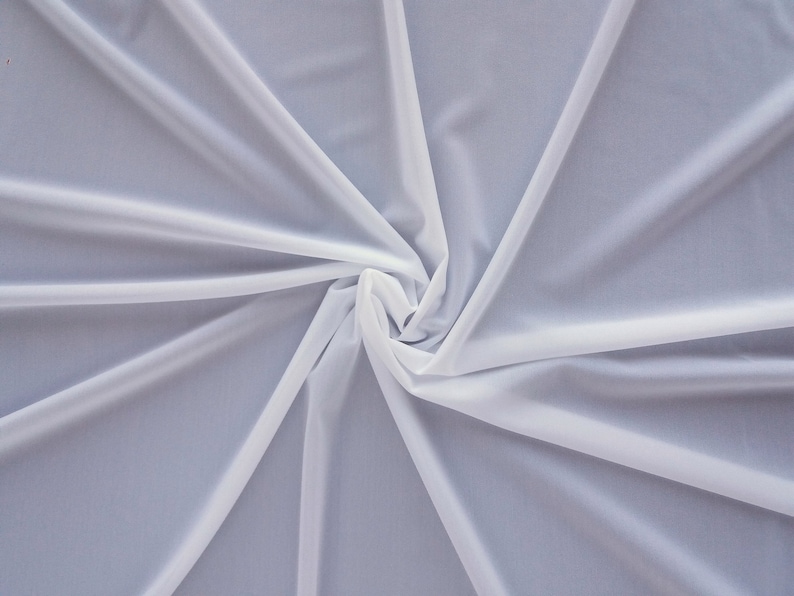 May include: White sheer fabric with a soft, flowing texture. The fabric is gathered in the center, creating a swirling pattern.